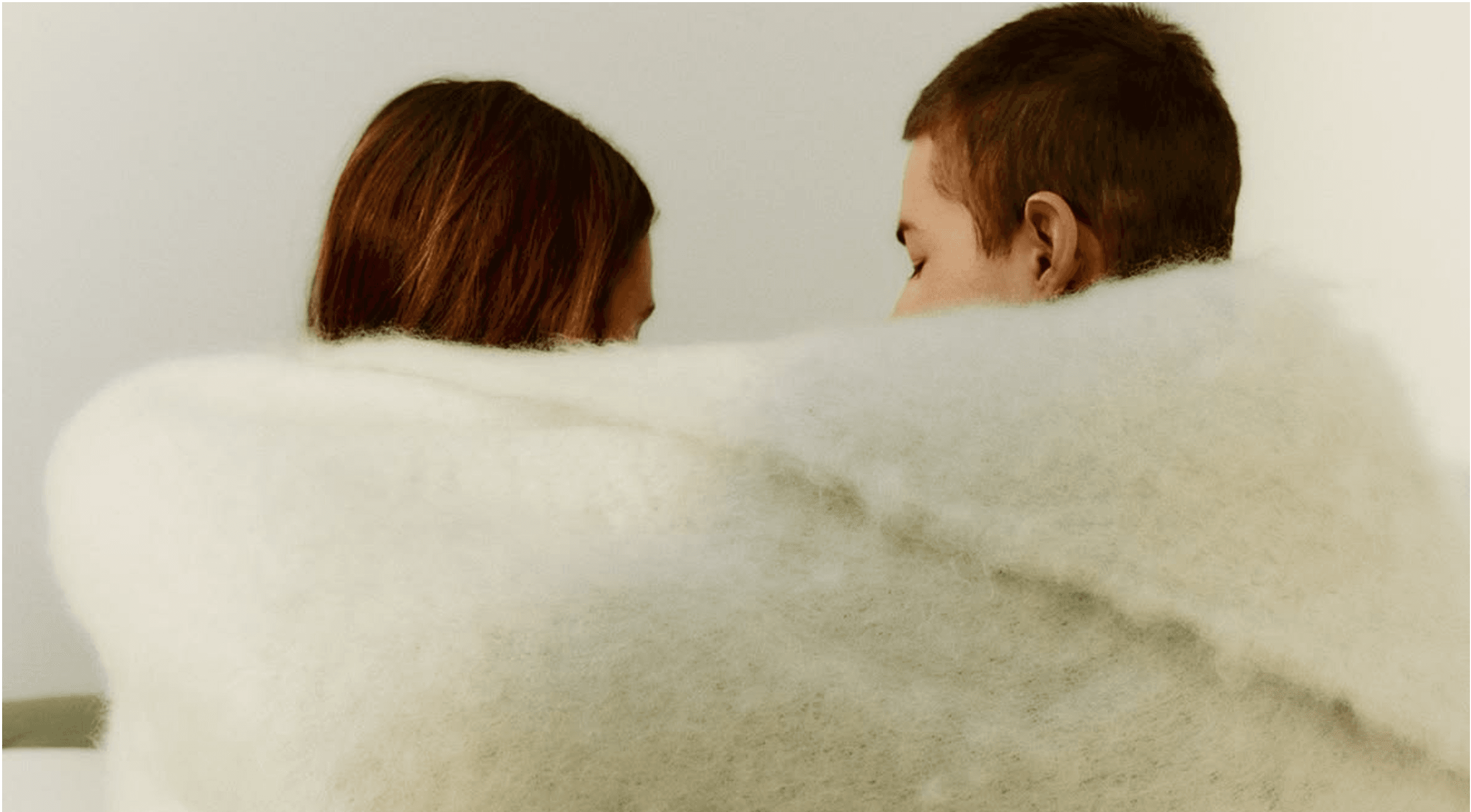 Two people wrapped in a soft blanket
