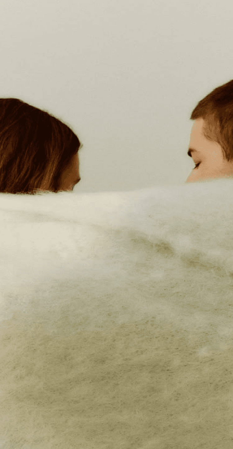 Two people wrapped in a soft blanket